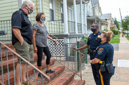 Officer Marlise Correa and Sergeant Bryant Myers, members of the  Rutgers University Police Department, talk with New Brunswick residents Mark and Joan Lomery