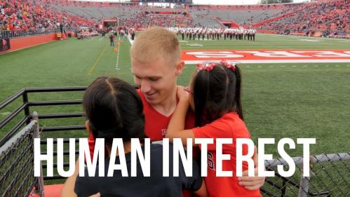 Rutgers cheerleader Andrew Geldreich hugs his deaf sisters