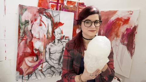 Alessandra Puglisi holds a head she sculpted from food wax for her senior thesis project.