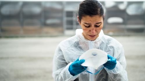 woman in protective equipment looking at a sample