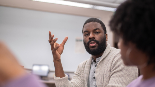 Teaching assistant Christopher Chukwuedo assists a student in the computer lab of the Center for Law and Criminal Justice