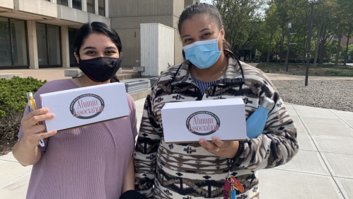 two members of RUAA holding boxes of PPE for donation
