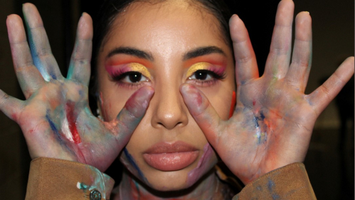 MGSA dance student Cassidy Rivas, posing with colorful paint on her face and hands