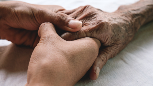 a younger hand holding an older hand