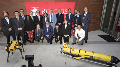 Secretary Gina Raimondo and Congressman Frank Pallone poses for a photo outdoors with Rutgers President Holloway and Rutgers researchers