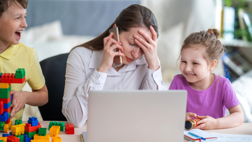 Mom working at home while caring for kids during COVID.