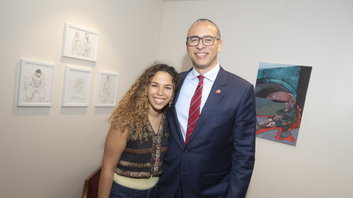 Tehyla McLeod with President Jonathan Holloway standing in front of her artwork that was selected to hang in the president's office suite