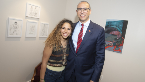 Tehyla McLeod with President Jonathan Holloway standing in front of her artwork that was selected to hang in the president's office suite