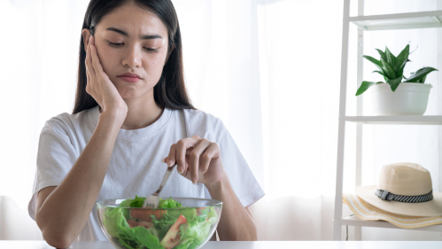 A young girl looking at a salad