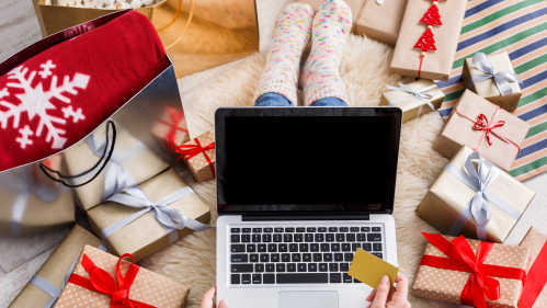 A person wrapping gifts and searching for gifts online