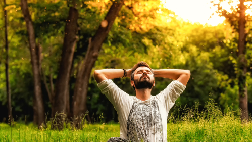 A male sits outdoors and meditates