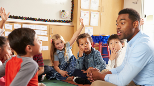 Teacher sitting down with a group of students