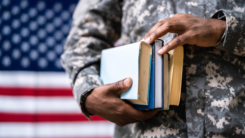 A military veteran holding school books