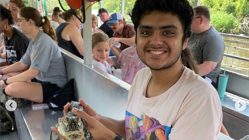 Rutgers student Anish Suresh holds a baby alligator while riding in a boat during a swamp tour near New Orleans in late July.