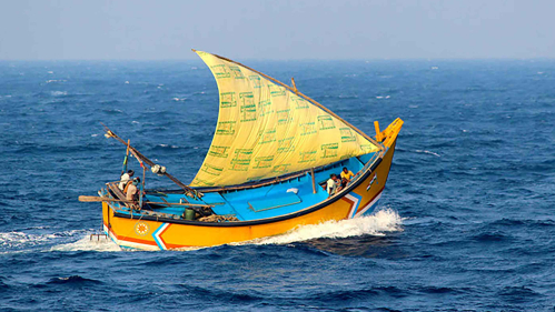 A sailboat with a yellow sail at sea in the Bay of Bengal.