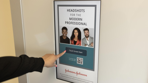 The hand of Rutgers sophomore Ismel Martinez Sanchez reaches for the touchscreen of the self-serve photo studio at the College Avenue campus.