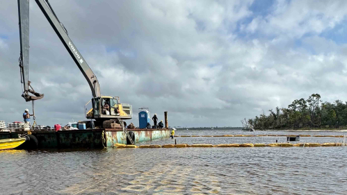 Crane on ocean with oyster reef under the surface