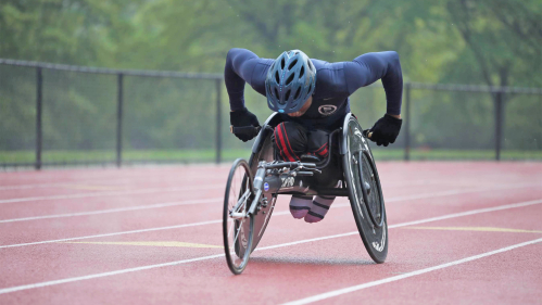 man in a wheelchair racing on a track