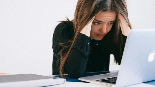 Women appears upset as she looks at her computer 