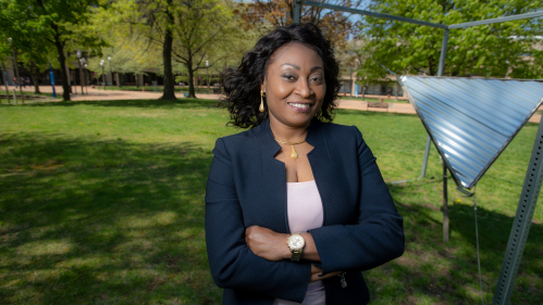 Chinwe Mercy Izegbu standing with her arms folded outside on campus