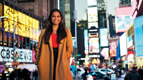 Erica D’Costa standing in Times Square, New York City.