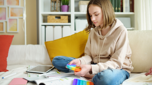 Teen with rainbow colored fidget toy