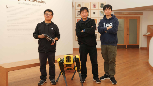 Fifth-year engineering student Chong Di (left), Professor Jie Gong and Shengyuan Feng, a graduate student studying artificial intelligence, pose with Echo the robot in the Zimmerli Art Museum.