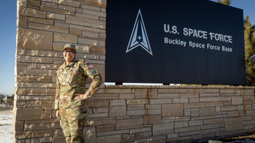Tennille Robbs in front of the Space Force base sign