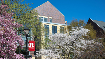 The Academic Building as seen through trees in bloom on an early spring afternoon.