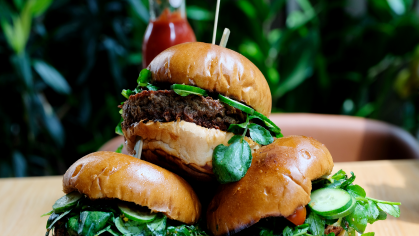 A plate piled with Impossible Burgers on a table.