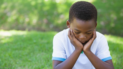 Young boy sitting outside