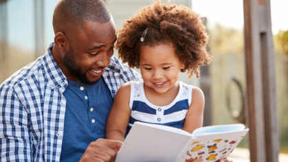 A father reading to his daughter