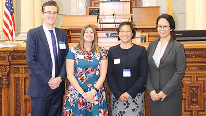 four law students standing in the front of a courtroom