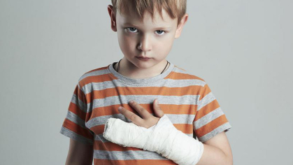 Boy with a cast on his arm and wrapping two of his fingers