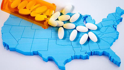 A bottle of pills spilling over a 3D cutout of the United States