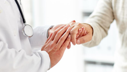 Image of doctor checking patient's hand