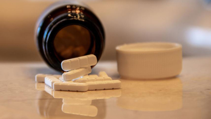Prescription bottle with pills coming out of it
