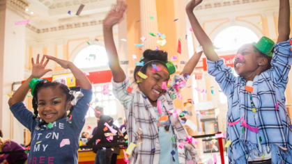 children with their arms raised in celebration