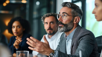 Male in a boardroom speaking to executives