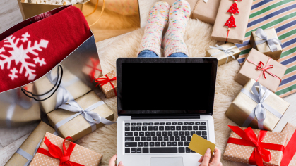 A person wrapping gifts and searching for gifts online 