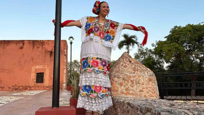 Alyssa McKendry – dressed in a terno, traditional formal attire in Yucatan – holds on to a light pole in the Mexican city of Tekax in May.