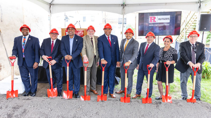 Dignataries in hard hats holding shovels at the groundbreaking 