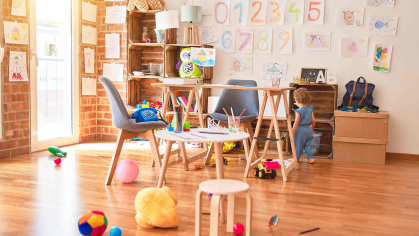 A room in a day care facility with small chairs and children's toys.