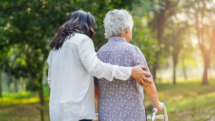 Women walking and supporting an elderly person