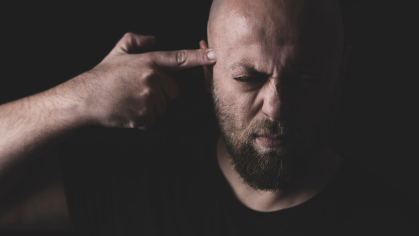 man points gun finger to his head