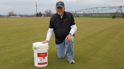  Richard Hurley GSNB’83 at the East Coast Sod & Feed farm in Salem County, New Jersey, with a bucket of turfgrass seed he developed. 