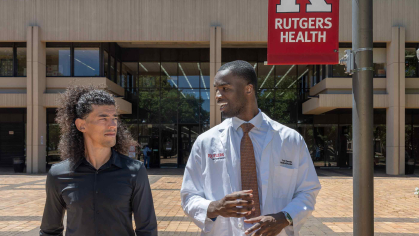Martial arts instructor Michael Loureiro (left) and Rutgers medical student Yvan Yomba walk and talk outside of New Jersey Medical School in Newark.