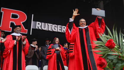 Freeman Hrabowski standing with his hands raised on the state at Rutgers commencement