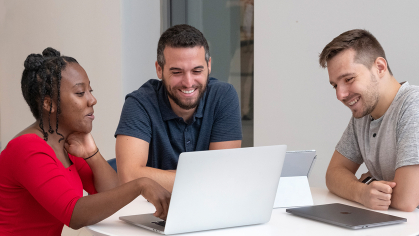 group of students working together at a laptop
