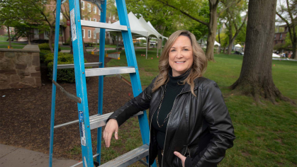 Patty Kastner leaning on a ladder outside